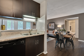 A modern kitchen with dark brown cabinets and a black dishwasher.